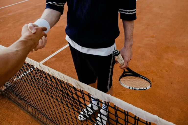 tennisspelare skakar hand över nätet