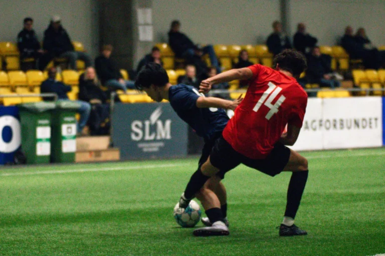 Två spelare som slåss om en boll medan collegetränare tittar på Keystone Sports College Soccer Showcase